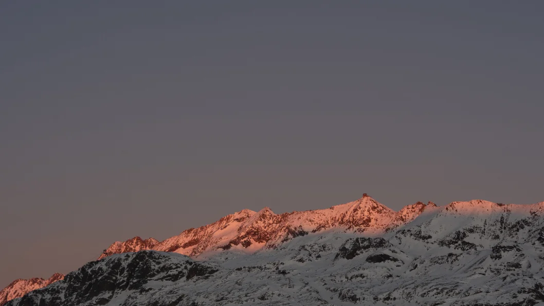 Des sommets enneigés dans la lumière du coucher du soleil.